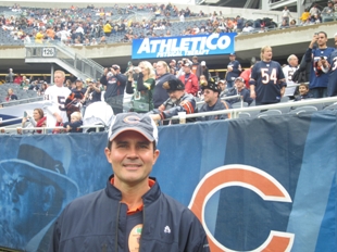AthletiCo President Mark Kaufman poses in front of AthletiCo's new LED display at Soldier Field.