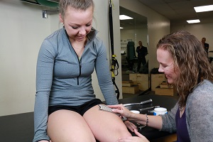 a clinician uses hawkgrips on a patient's thigh